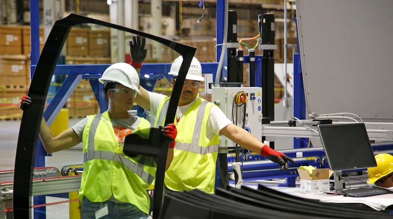 Workers in the Fuyao Glass America Moraine plant hard at work in 2020, stacking newly manufactured windshields. FILE