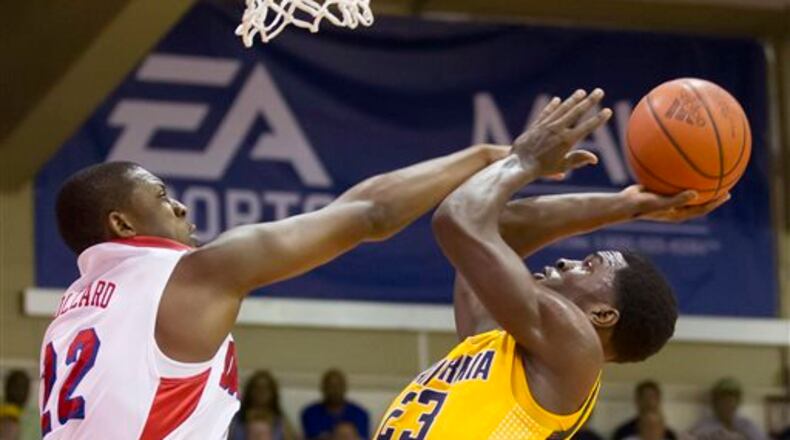 Dayton forward Kendall Pollard, left, attempts to block a shot by California guard Jabari Bird (23) in the second half of an NCAA college basketball game at the Maui Invitational on Wednesday, Nov. 27, 2013, in Lahaina, Hawaii. Dayton won 82-64. (AP Photo/Eugene Tanner)
