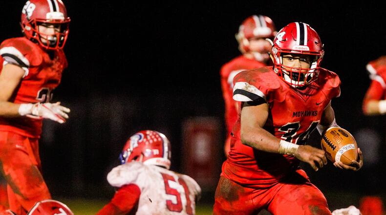 Madisonâs Evan Crim eyes the Portsmouth defense during Saturday nightâs 26-0 victory for the Mohawks in a Division V, Region 20 playoff game at Brandenburg Field in Madison Township. NICK GRAHAM/STAFF