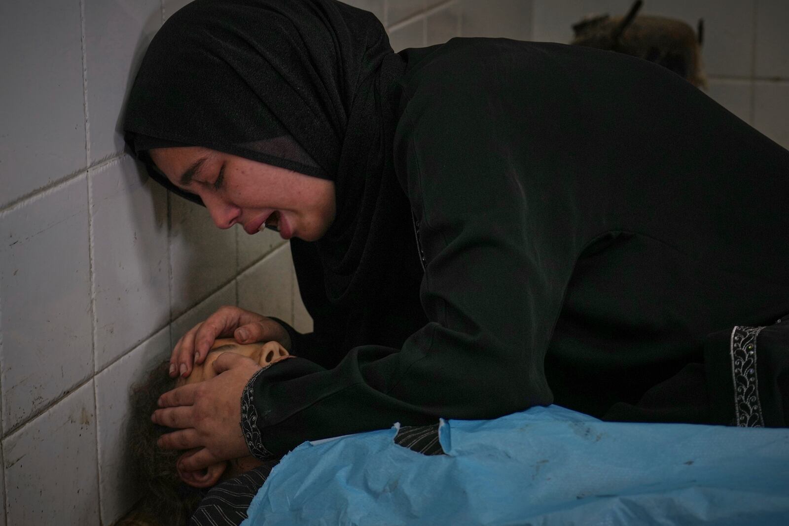 Sara Al-Nouri mourns over the body of her 13-year-old sister, Sama, who was among 10 people, including two women and five children, killed in an Israeli strike while they were waiting to receive nutritional supplements at a Project Hope-run medical clinic in Deir al-Balah, Gaza Strip, Thursday, July 10, 2025. (AP Photo/Abdel Kareem Hana)