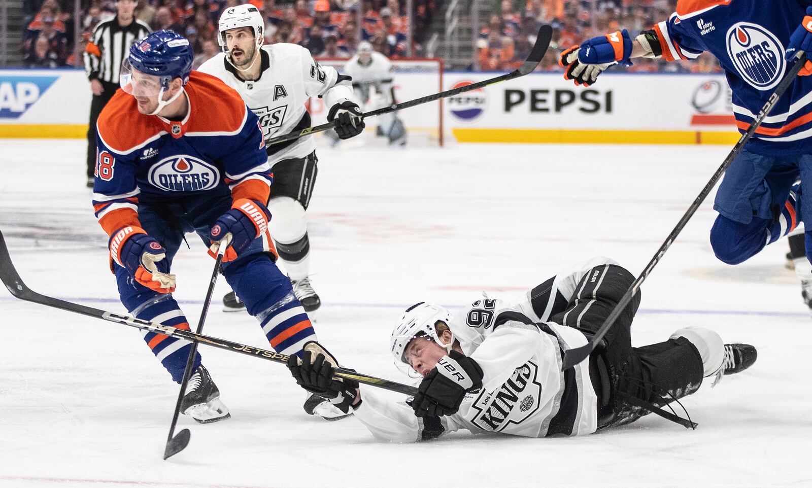Los Angeles Kings' Brandt Clarke (92) is knocked down by Edmonton Oilers' Zach Hyman (18) during the first period of an NHL hockey playoff game in Edmonton, Alberta, Sunday, April 27, 2025. (Jason Franson/The Canadian Press via AP)