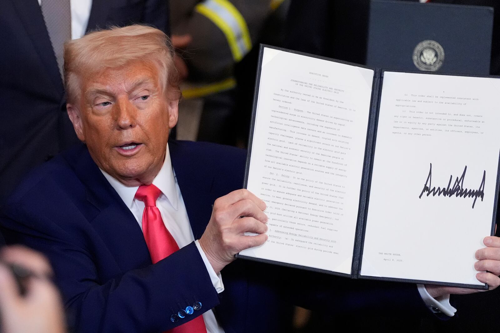 President Donald Trump holds a signed an executive order during an event in the East Room of the White House, Tuesday, April 8, 2025, in Washington. (AP Photo/Alex Brandon)