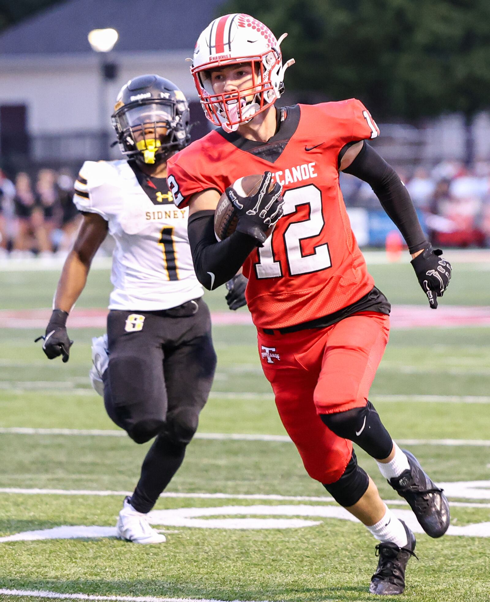 Tippecanoe senior running back Max Deckard runs ahead of Sidney's Jamari Combs during a 35-yard interception return for a touchdown on Thursday, Sept. 25 at Tipp City Park. BRYANT BILLING / STAFF