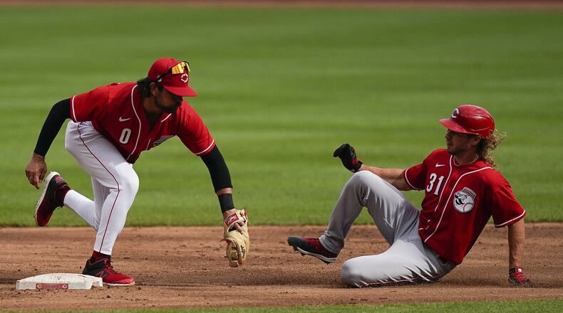 Cincinnati Reds shortstop Alex Blandino (0) tags out Travis Jankowski (31) during team baseball practice at Great American Ballpark in Cincinnati, Friday, July 10, 2020. (AP Photo/Bryan Woolston)