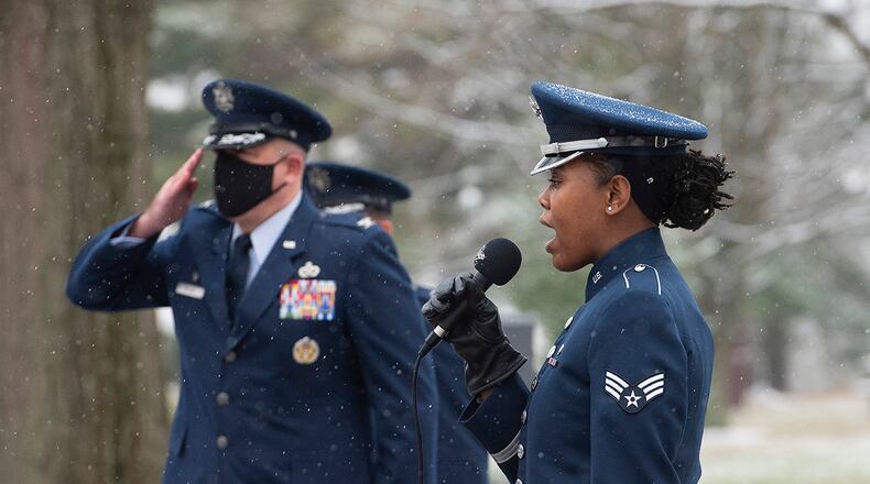 Senior Airman MeLan Smartt sings the national anthem as Col. Patrick Miller, 88th Air Base Wing and installation commander, salutes during the 2020 First Flight ceremony Dec. 17 at the Wright Brothers Memorial. U.S. AIR FORCE PHOTO/R.J. ORIEZ