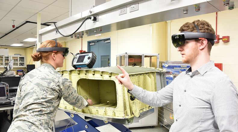 Air Force Research Laboratory Materials and Manufacturing Directorate researchers Capt. Sarah Wallentine and Alex Brown demonstrate the use of augmented reality for nondestructive inspections. AFRL researchers are developing a capability that uses the technology to display all necessary information for performing an aircraft inspection within the user’s field of view, eliminating the need to view information from multiple sources simultaneously. (U.S. Air Force photo/David Dixon)