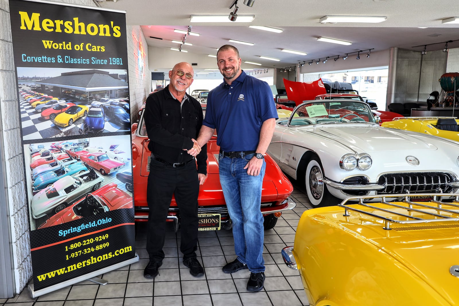 Dan Mershon (left) shakes new owner Jeff Warrington's hand at Mershon's World of Cars. CONTRIBUTED