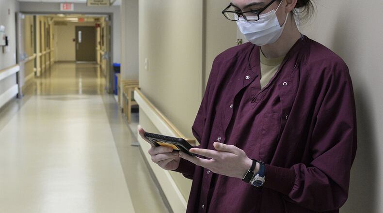 Airman 1st Class Rehanna Payne, a medical technician, uses medical monitoring technology called the Battlefield Assisted Trauma Distributed Observation Kit, or BATDOK, to check the vitals of a patient while she stands in a hallway of the Wright-Patterson Medical Center April 28. The Air Force Research Laboratory adapted this technology, originally developed for the pararescue community, for medical facilities during the COVID-19 pandemic. (U.S. Air Force photo/ Wesley Farnsworth)