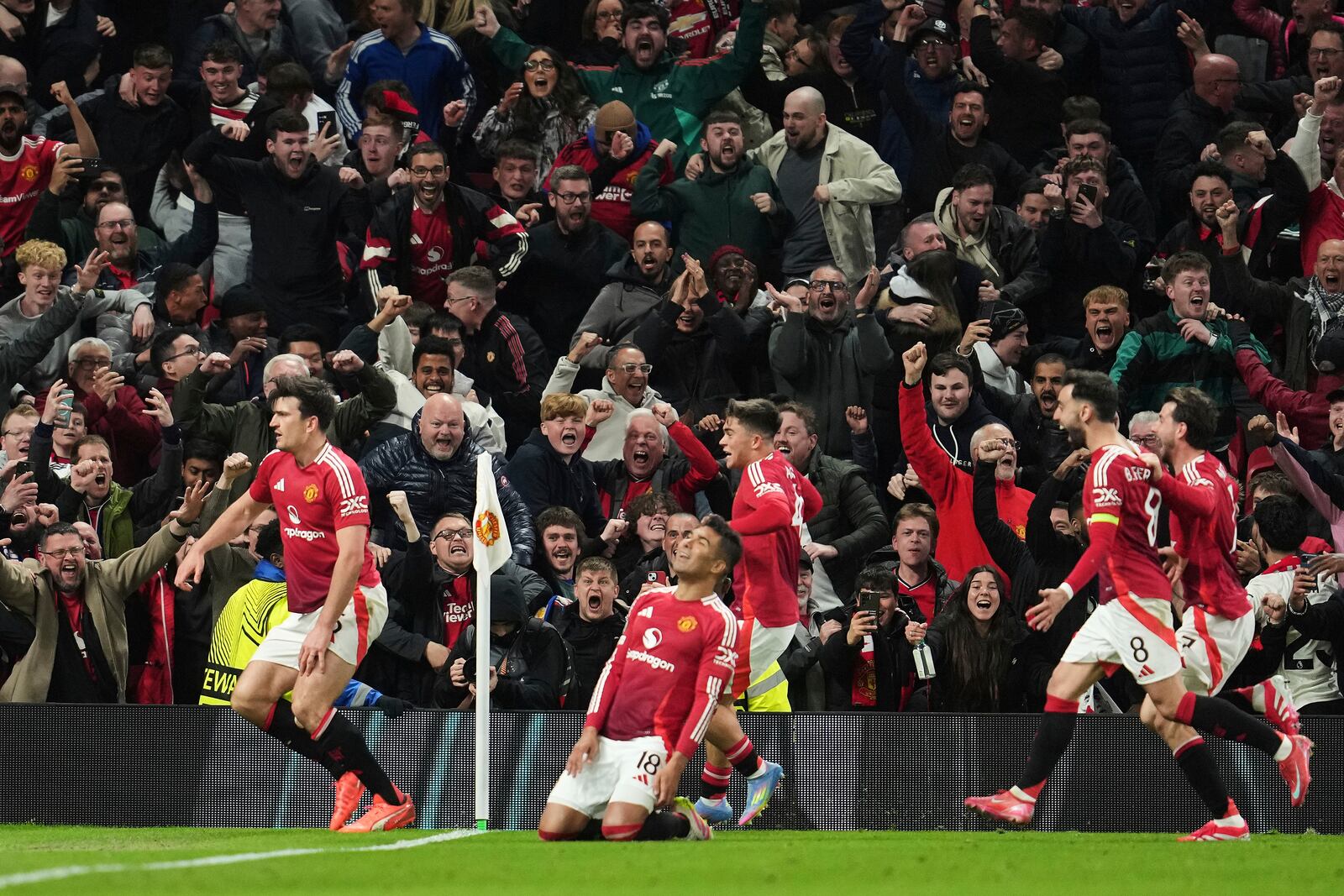 Manchester United's Harry Maguire, left, celebrates with team mates after his side's fifth goal during the Europa League quarter final second leg soccer match between Manchester United and Olympique Lyon in Manchester, Britain, Thursday, April 17, 2025. (AP Photo/Jon Super)