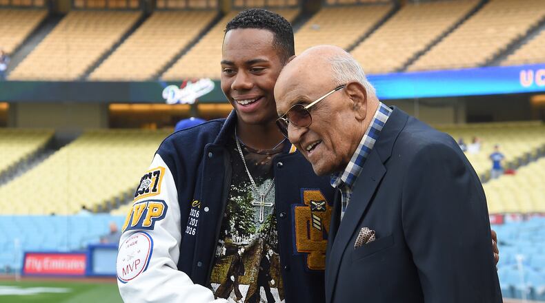 Former high School baseball player Hunter Greene, from Stevenson Ranch, Calif., tripled for the Reds' Pioneer Rookie League team in Billings, Mont. Tuesday night in his first professional game. Here, he's seen visiting with Hall of Famer Don Newcombe during batting practice before a game against the Phillies at Dodger Stadium on April 28.