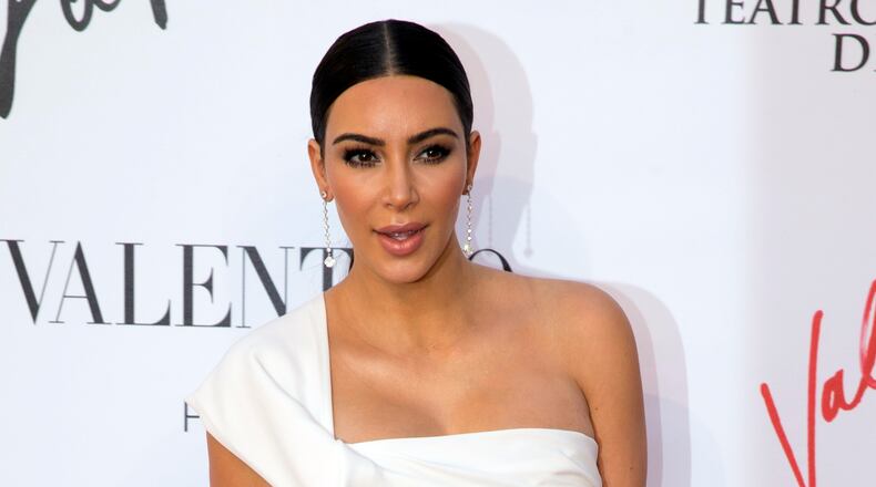 FILE - In this Sunday, May 22, 2016 file photo, Kim Kardashian poses for photographers as she arrives for the premiere of Verdi’s ‘’La Traviata’’ at the Rome Opera House, in Rome. Serial celebrity prankster Vitalii Sediuk has struck again, this time at Paris Fashion Week, targeting Kim Kardashian’s derriere as she was entering the L'Avenue restaurant. Kardashian’s makeup artist caught the Wednesday, Sept. 28, 2016 incident in a video that he posted to his Instagram account. It shows the reality television star negotiating her way through a crowd of paparazzi past her black car, as Sediuk, a former Ukrainian television reporter, swoops in and seems to attempt to kiss Kardashian’s posterior. (AP Photo/Andrew Medichini, file)