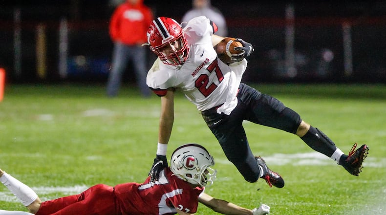 Madison’s Gabe Higgs carries the football defended by Carlisle’s Jayden Sweeney during their game Friday night, Oct. 11, 2019 at Laughlin Field in Carlisle. Madison won 26-16. NICK GRAHAM/STAFF