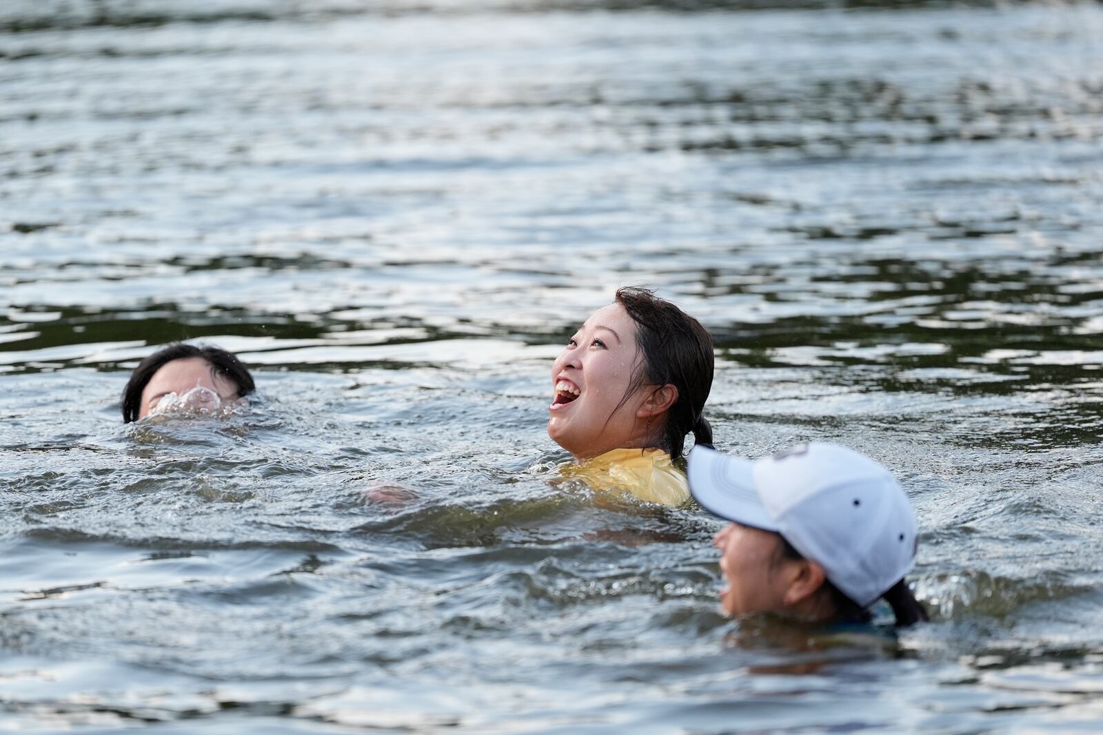 Mao Saigo, of Japan, in yellow, swims in the water after winning the Chevron Championship LPGA golf tournament Sunday, April 27, 2025, in The Woodlands, Texas. (AP Photo/Ashley Landis)