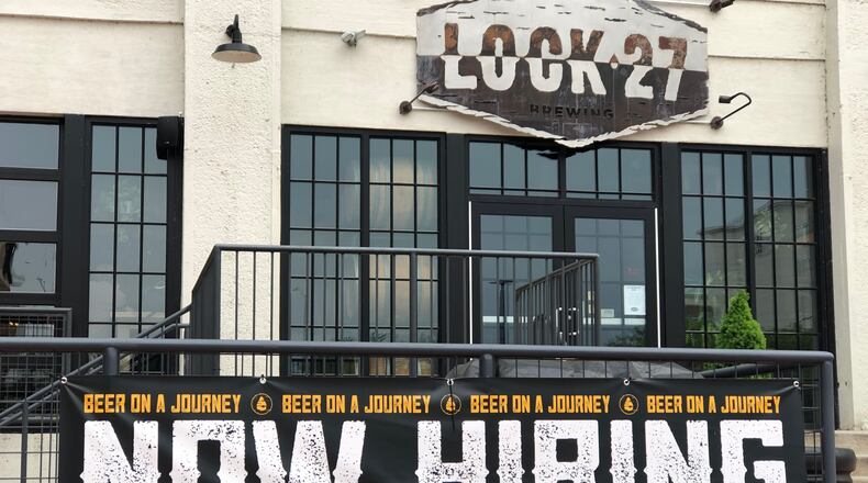 A "now hiring" sign outside of Lock 27 Brewing in downtown Dayton. Lock 27 has several job openings posted on its website. CORNELIUS FROLIK / STAFF