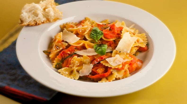 Butterfly pasta (aka farfalle) is tossed with a quick sauce of smashed cherry tomatoes, onion, garlic, herbs and grated Parmesan. (Bill Hogan/ Chicago Tribune/TNS)