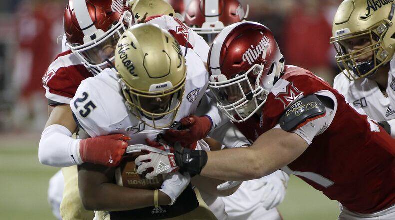 OXFORD, OHIO - NOVEMBER 20: Tyler Gilchrist #25 of the Akron Zips is tackled by the Miami of Ohio Redhawks during the second quarter at Yager Stadium on November 20, 2019 in Oxford, Ohio. (Photo by Justin Casterline/Getty Images)