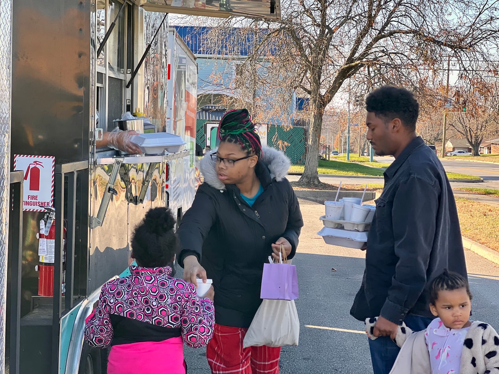 A family stopped by the community give back event in Huber Heights on Sunday, hosted by three local women-owned businesses. AIMEE HANCOCK/STAFF