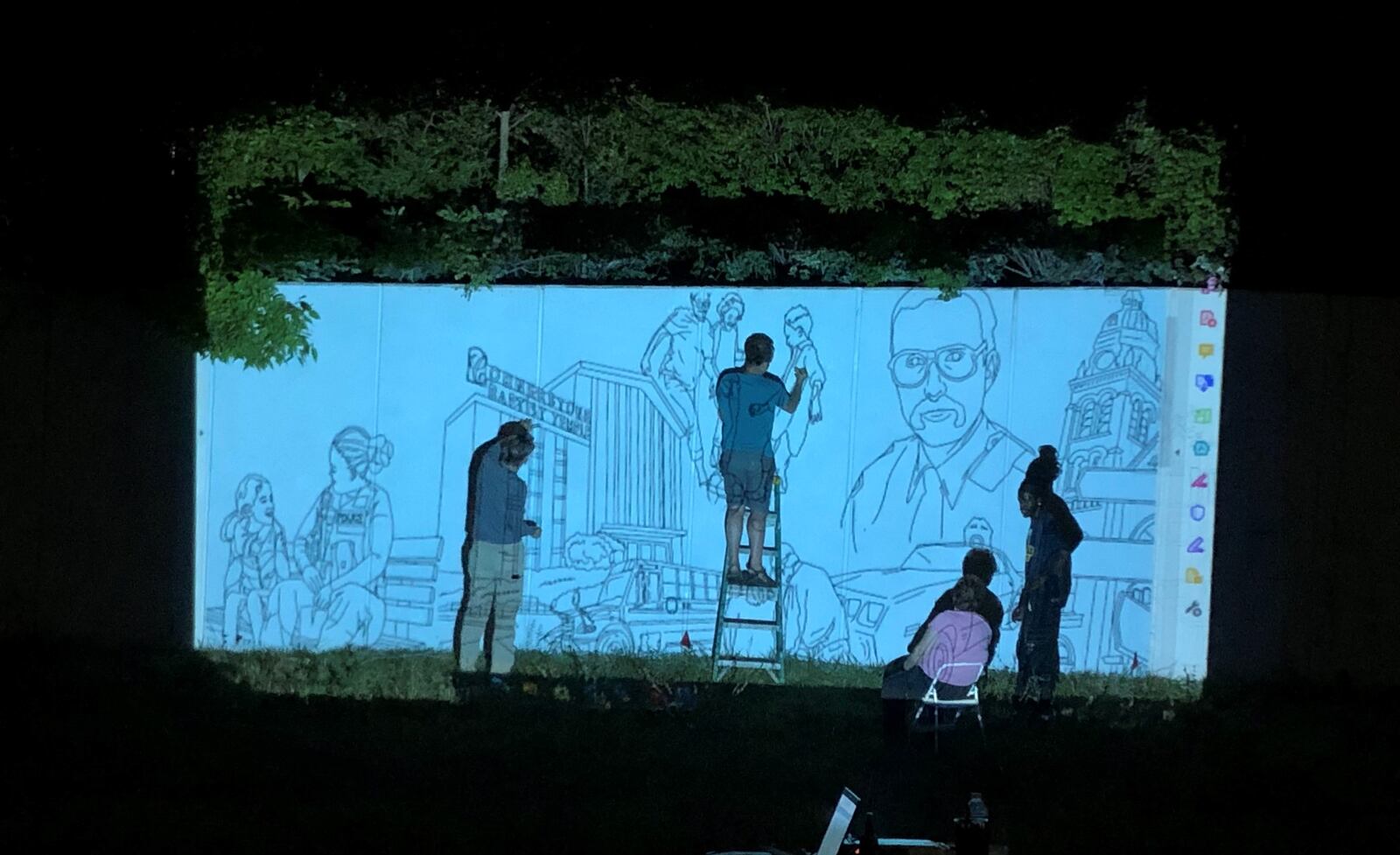 Jason Antonick and others use a projector to sketch some of the images for the new Steve Whalen mural in August. CORNELIUS FROLIK / STAFF