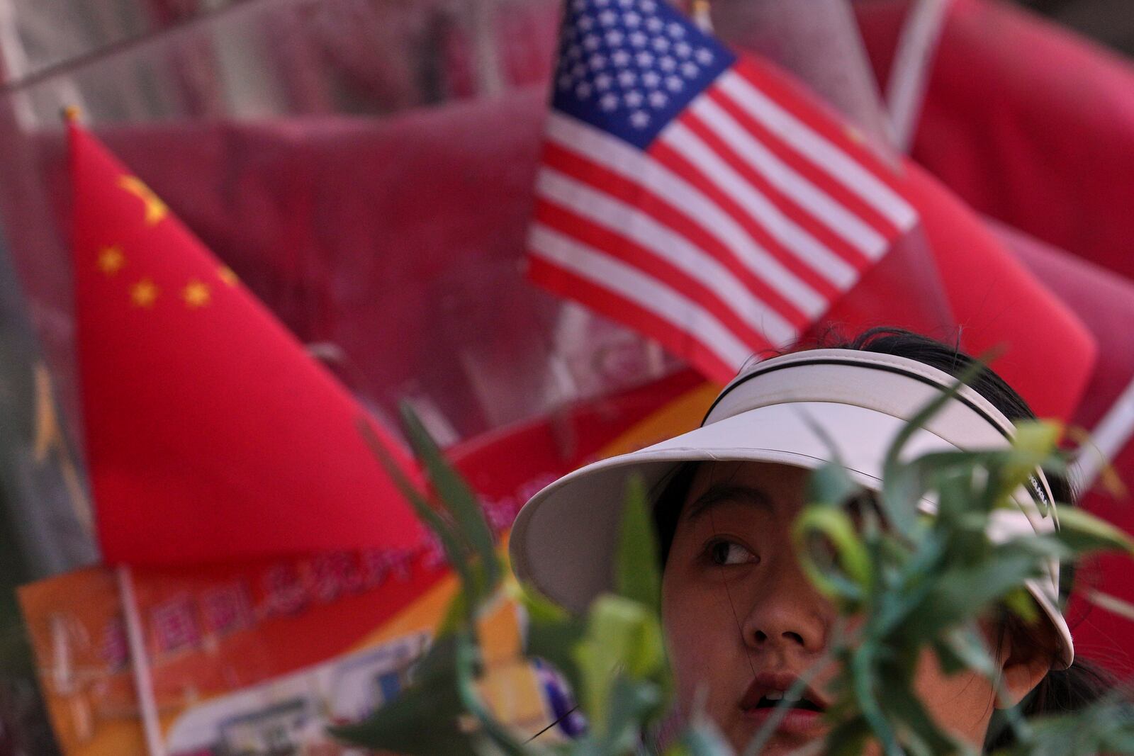 A woman walks past Chinese and United States' national flags on display at a merchandise store in Beijing, Thursday, April 3, 2025. (AP Photo/Andy Wong)