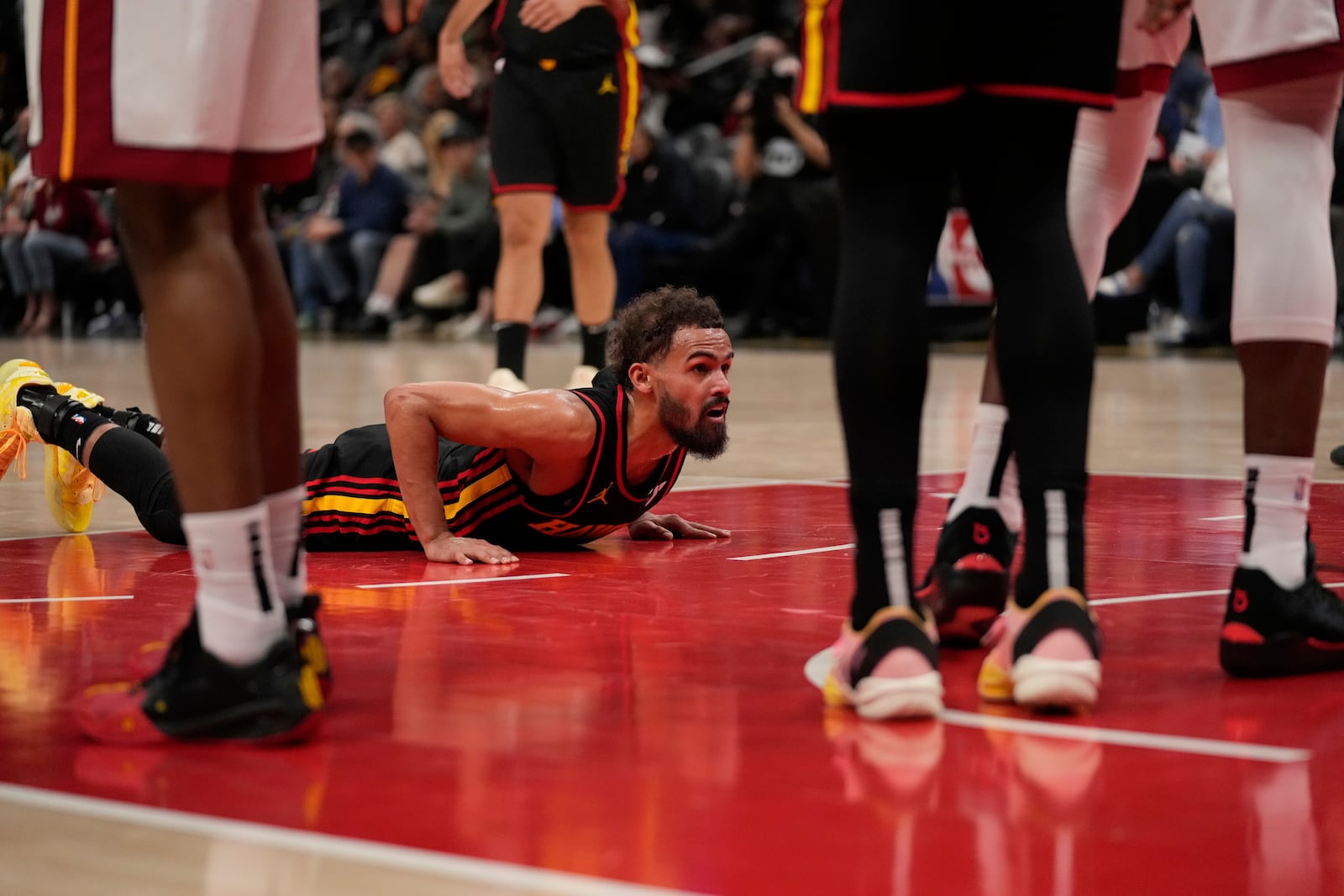 Atlanta Hawks guard Trae Young (11) falls and gets a foul in the first half of an NBA play-in tournament basketball game against the Miami Heat, Friday, April 18, 2025, in Atlanta. (AP Photo/Brynn Anderson)
