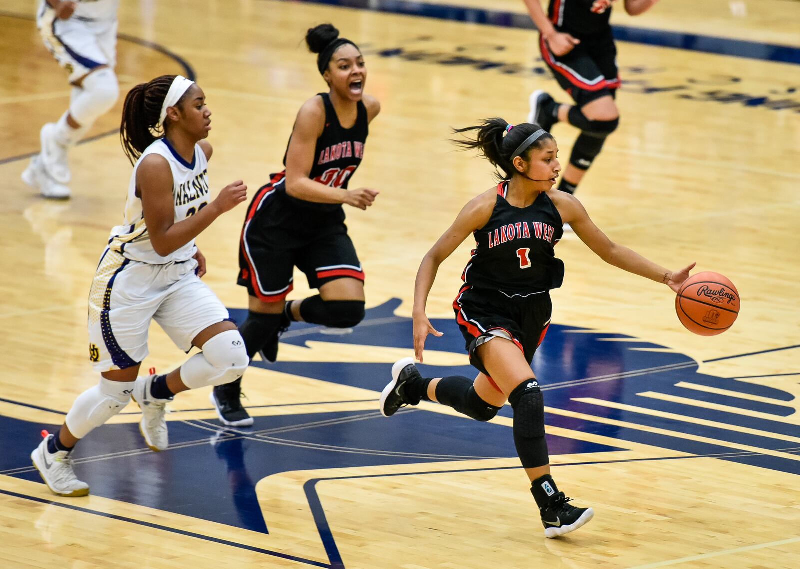 Lakota West's Bryana Henderson (1) dribbles up the court as teammate Jaydis Gales (00) trails during Wednesday night’s Division I regional semifinal at Fairmont’s Trent Arena. NICK GRAHAM/STAFF