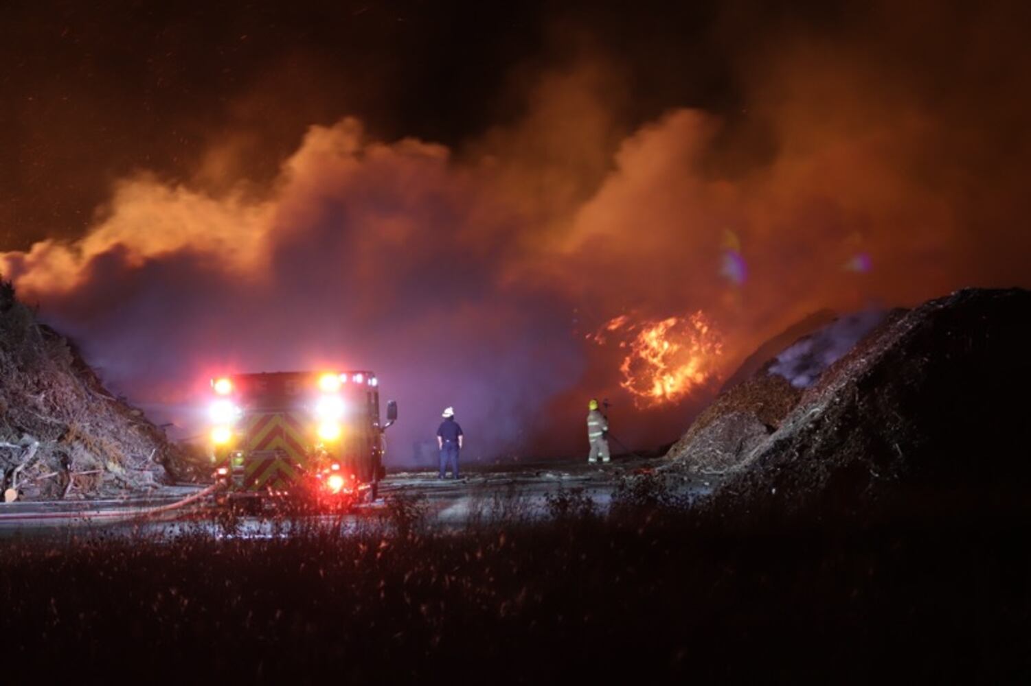 Fire crews battling huge fire in wood piles on Harshman Road