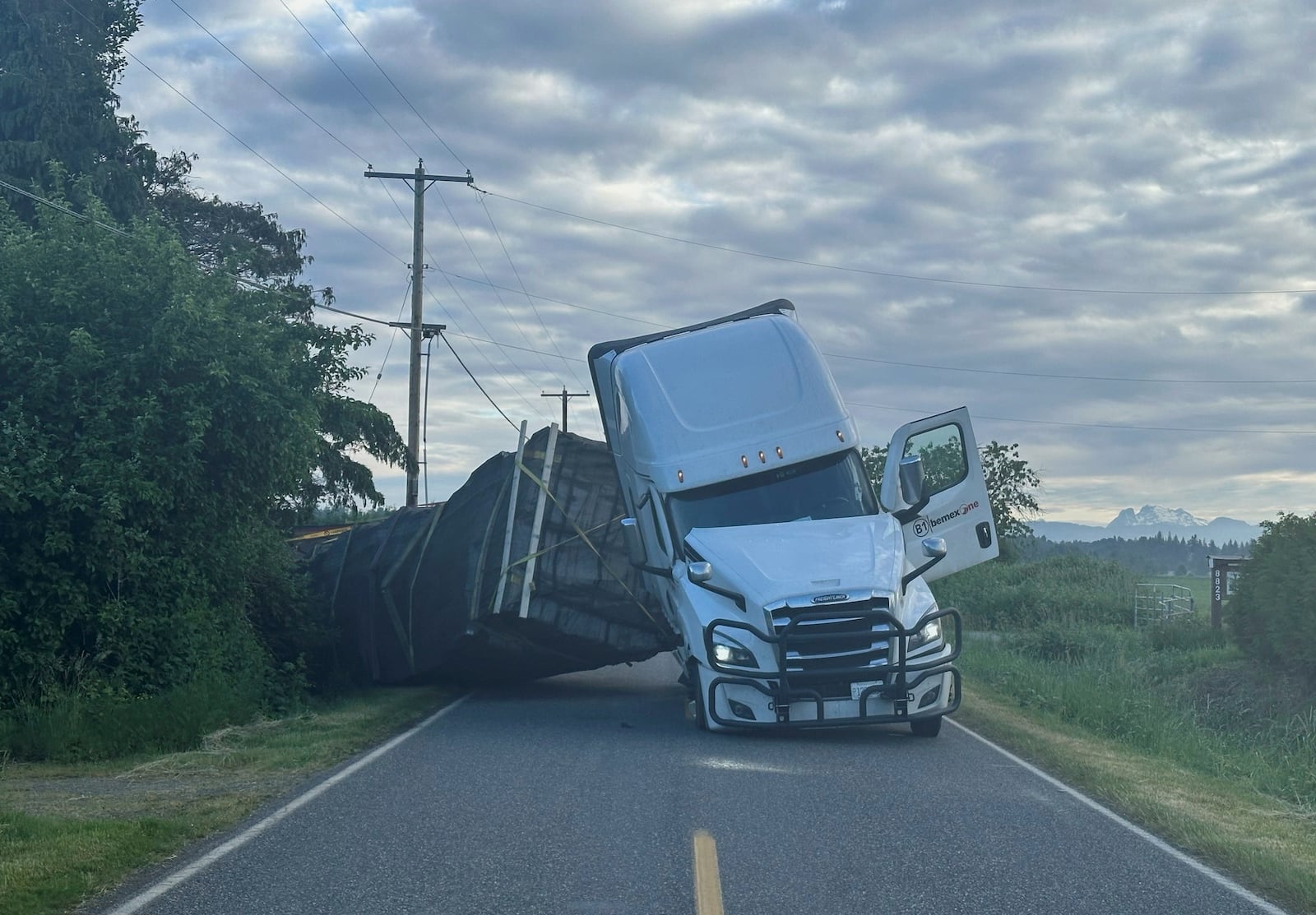 This image taken from video provided by Whatcom County Sheriff's Office shows a truck hauling an estimated 70,000 pounds of honeybee hives overturn on Friday, May 30, 2025 near Lynden, Wash. (Whatcom County Sheriff's Office via AP)