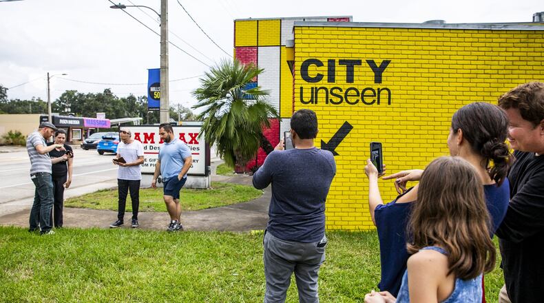 People walk through an artist’s studio in augmented reality during a public walk of the ‘CITY unseen’ augmented reality exhibit in Orlando on Sunday, Nov. 4, 2018. (Patrick Connolly/Orlando Sentinel/TNS)