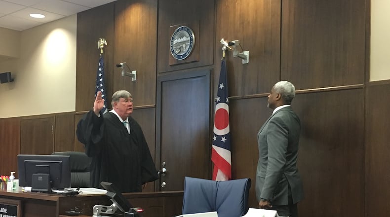 Dunbar High School varsity basketball coach Chuck Taylor is sworn in by Judge Michael Krumholtz on Tuesday, March 6, in Montgomery County Common Pleas Court. Dayton Public Schools sued the OHSAA for its decision to remove Dunbar from the boys basketball tournament after the state alleged an ineligible player participated in a win over Thurgood Marshall. JEREMY KELLEY/STAFF