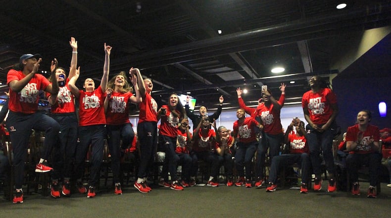 Dayton players react to earning a berth in the NCAA women’s tournament at UD Arena on Monday, March 12, 2018. David Jablonski/Staff