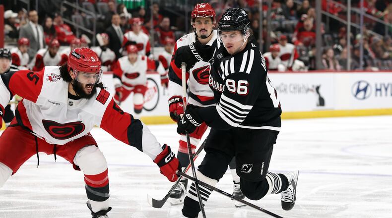 New Jersey Devils center Jack Hughes (86) has his shot knocked away by Carolina Hurricanes defenseman Jalen Chatfield (5) during the second period of an NHL hockey game Saturday, Jan. 17, 2026, in Newark, N.J. (AP Photo/Adam Hunger)