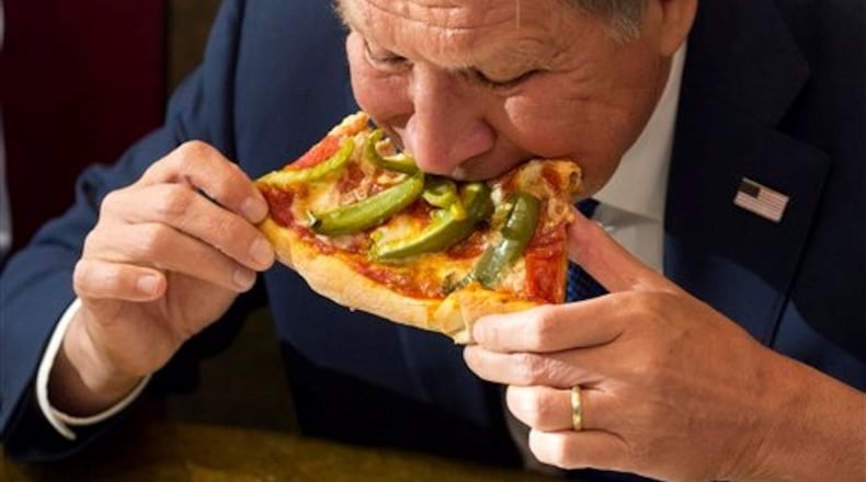 Gov. John Kasich eats pizza WITHOUT a knife and fork, too. ASSOCIATED PRESS