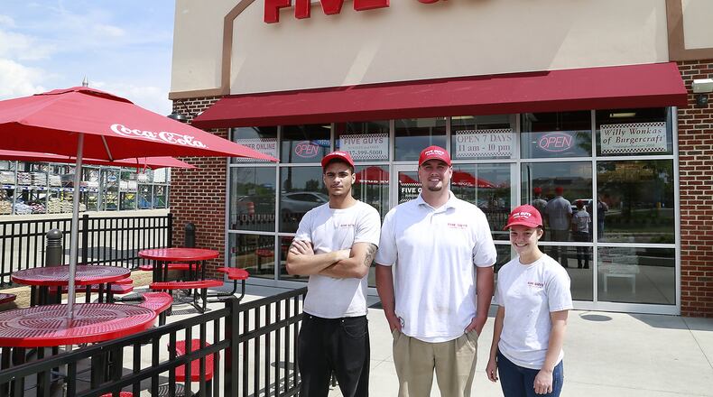 Five Guys with the management staff, Damon Roush, David Day and Autum Baer in front of the Bechtle Avenue location. BILL LACKEY/STAFF