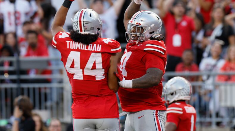 Ohio State defensive lineman Tyleik Williams, right, celebrates his fumble recovery and touchdown against Western Kentucky with teammate J.T. Tuimoloau during the second half of an NCAA college football game, Saturday, Sept. 16, 2023, in Columbus, Ohio. (AP Photo/Jay LaPrete)