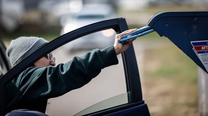 A customer drops off mail at the U.S. Post Office on East Stroop Road in Kettering. Dozens of cases of check theft have been reported this year from USPS drop boxes in local communities. JIM NOELKER/STAFF