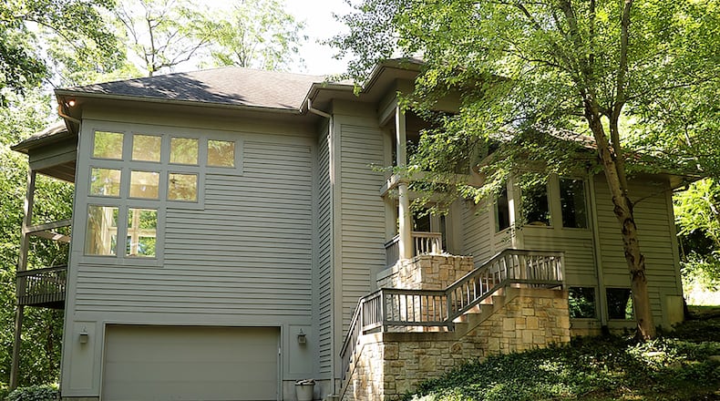 The contemporary 2-story with a southwest flare has about 4,670 sq. ft. of living space. The home, which has 3 or 4 bedrooms, sits on 5.74 wooded acres in the River Ridge area of Sugarcreek Twp. A paved driveway curves among the trees to a concrete parking pad and driveway to the oversized, 2-car garage. CONTRIBUTED PHOTO BY KATHY TYLER