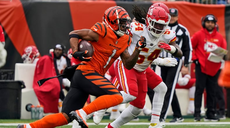 Cincinnati Bengals wide receiver Ja'Marr Chase (1) avoids Kansas City Chiefs outside linebacker Nick Bolton (54) for a 72-yard touchdown during the first half of an NFL football game, Sunday, Jan. 2, 2022, in Cincinnati. (AP Photo/Jeff Dean)