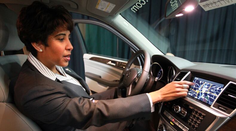 Bob Ross Auto Group President Jenell Ross works on a new Mercedes ML350 dashboard GPS at the Dayton Auto Show in this 2012 file photo.