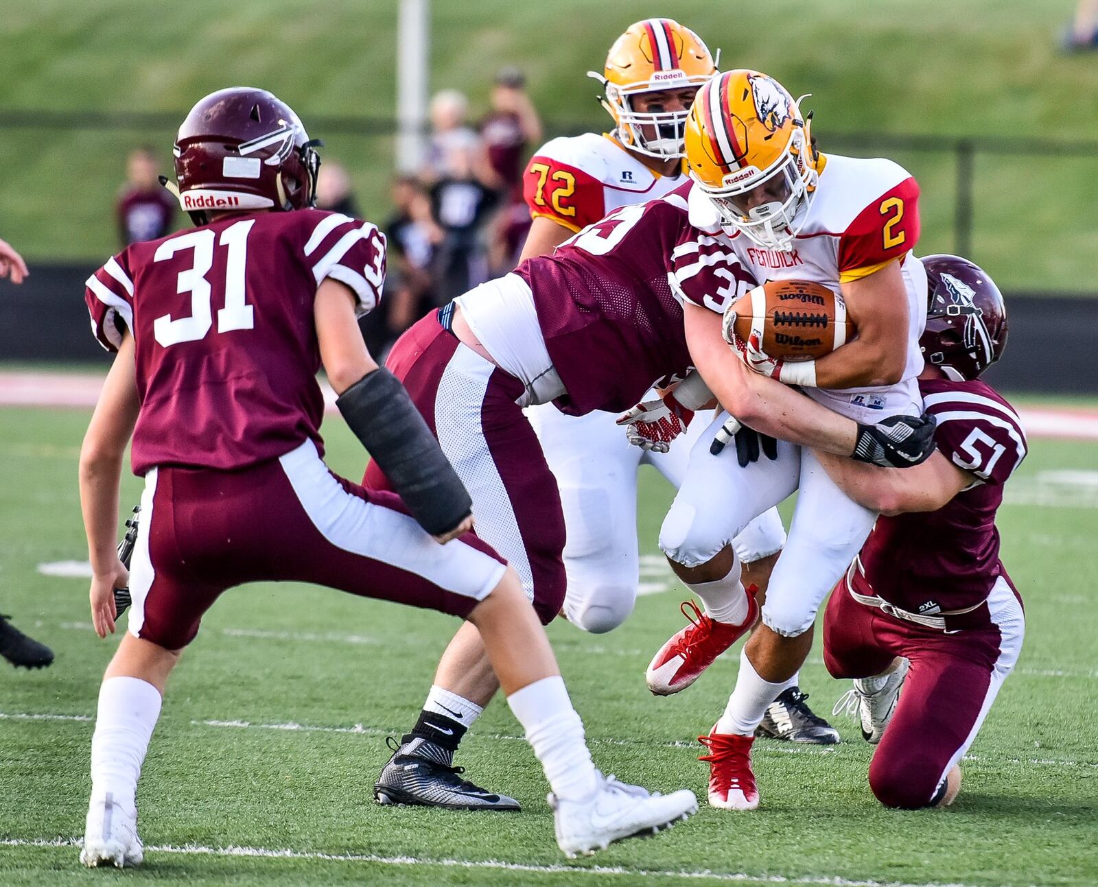 Fenwick’s R.J. Clesceri (2) is tackled by Lebanon’s Zack Ball (35) and Collin Mailhot (51) during their game Friday night at VanDeGrift Stadium in Lebanon. NICK GRAHAM/STAFF