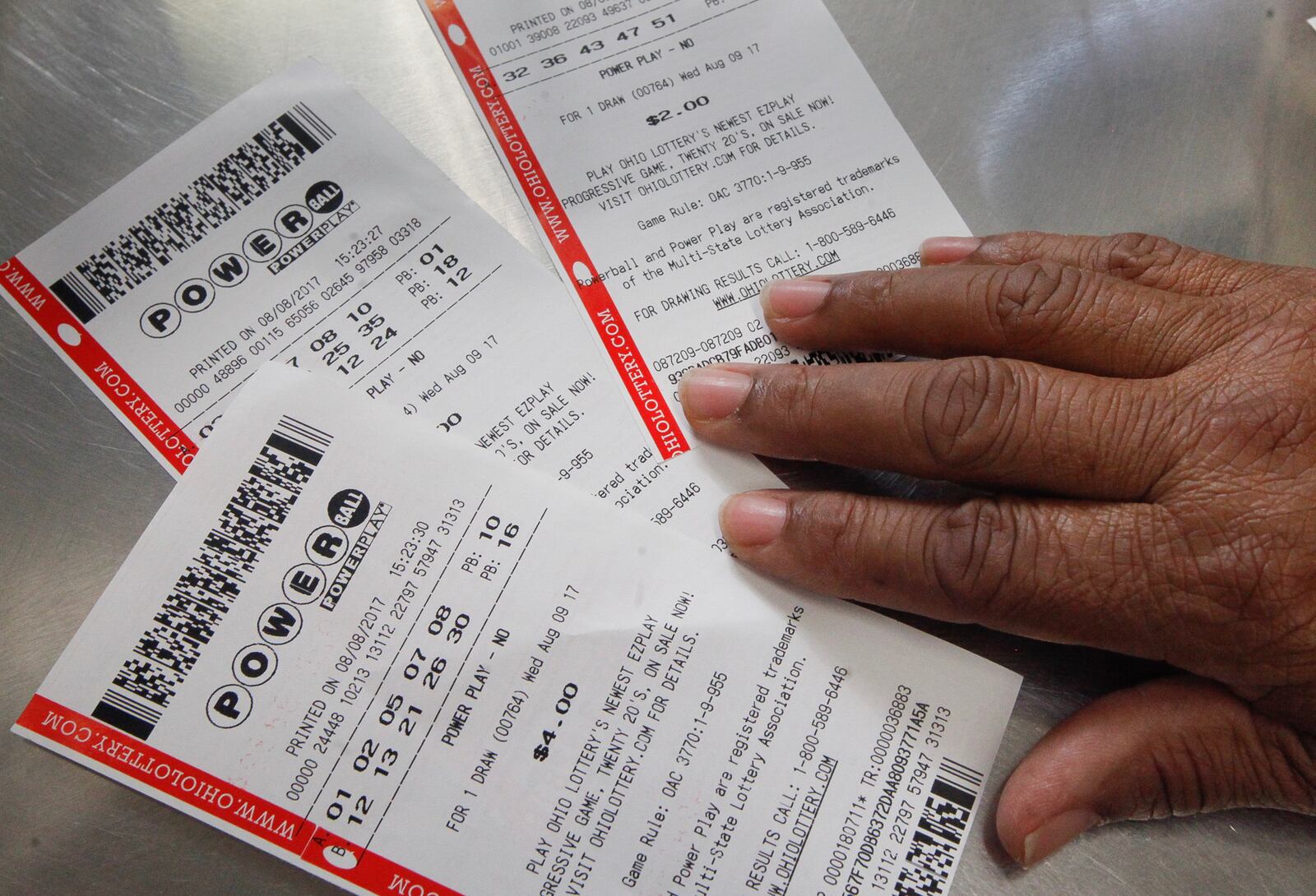 A patron at Bee Gee's Mini Market in Kettering displays their Powerball tickets for Saturday's drawing that could win someone more than $535 million. CHRIS STEWART / STAFF