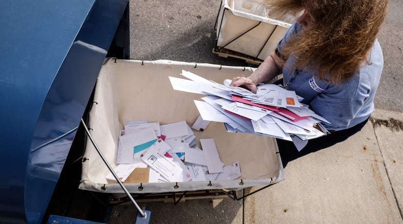 Lead Sales Associate, Theresa Warych empties the mailboxes in front of the U.S. Post Office on Stroop Rd. in Kettering Wednesday March 30, 2022. Four men, one from Dayton, were recently charged with a string of check thefts from U.S. Postal Service mailboxes in Oakwood and Kettering. JIM NOELKER/STAFF