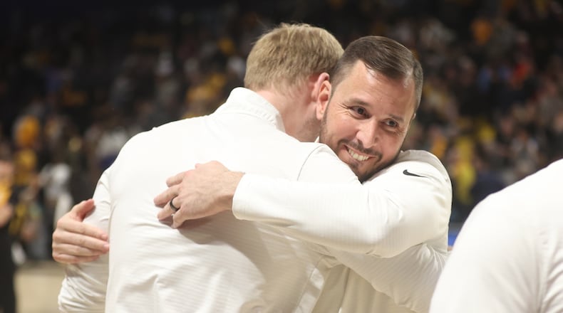 Dayton's James Kane, right, hugs CJ Napier after a victory against Virginia Commonwealth on Friday, March 7, 2025, at the Siegel Center in Richmond, Va. David Jablonski/Staff