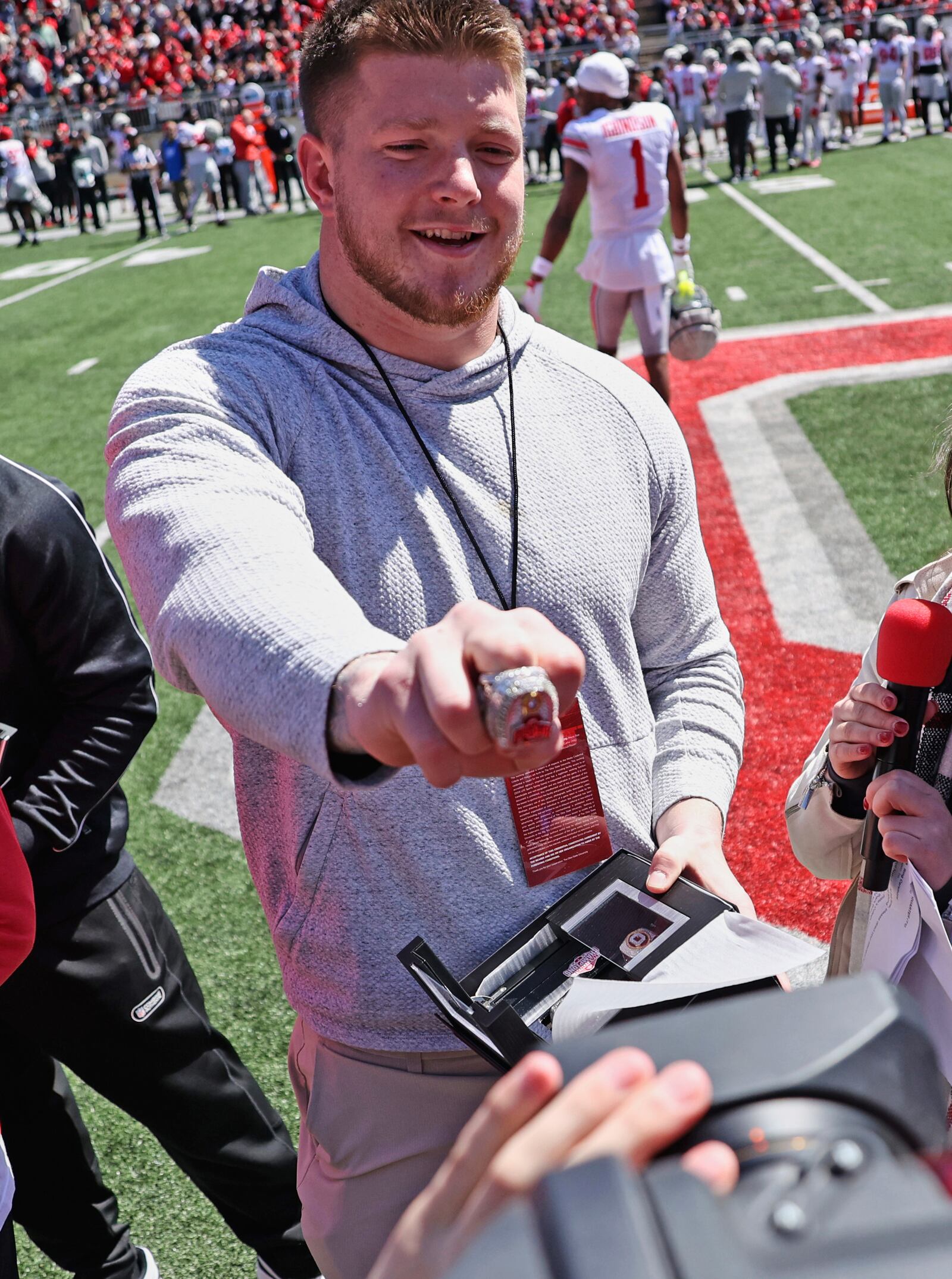 Ohio State's Jack Sawyer shows off his NCAA college football championship ring to a TV camera during the school's spring football game, Saturday, April 12,2 025, in Columbus, Ohio. (David Petkiewicz/Cleveland.com via AP)
