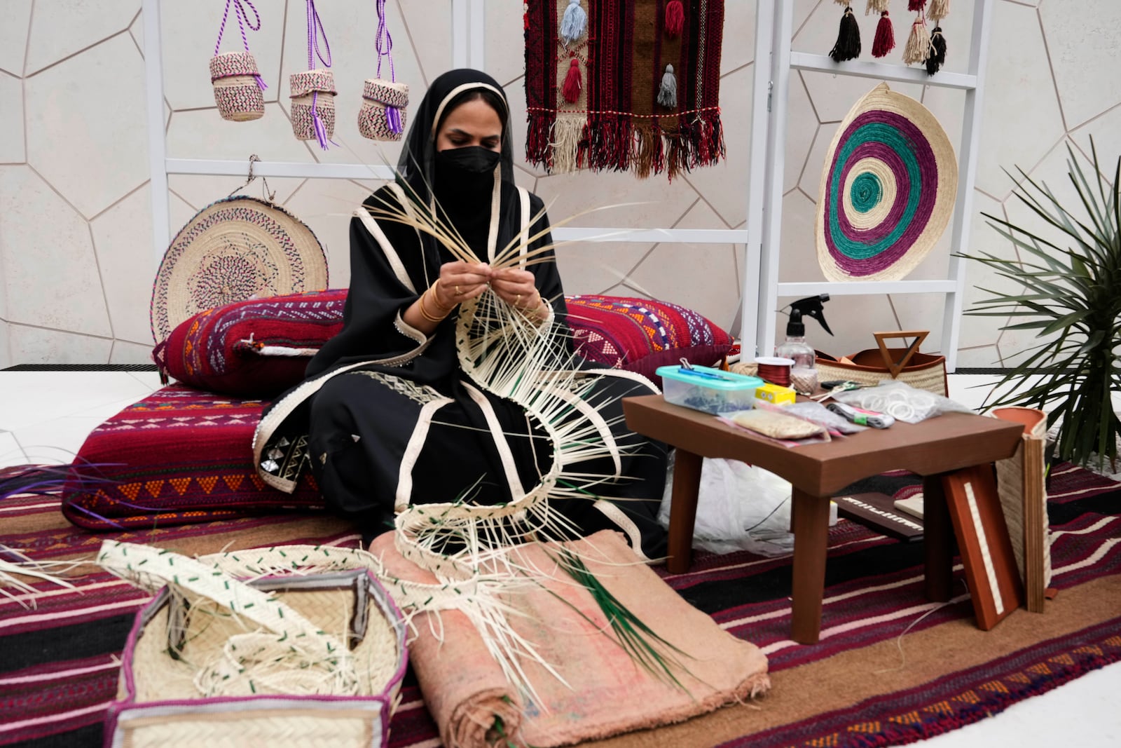 A women demonstrates weaving at Saudi Arabia's pavilion during the Expo 2025 in Osaka, western Japan, Tuesday, April 15, 2025. (AP Photo/Hiro Komae)