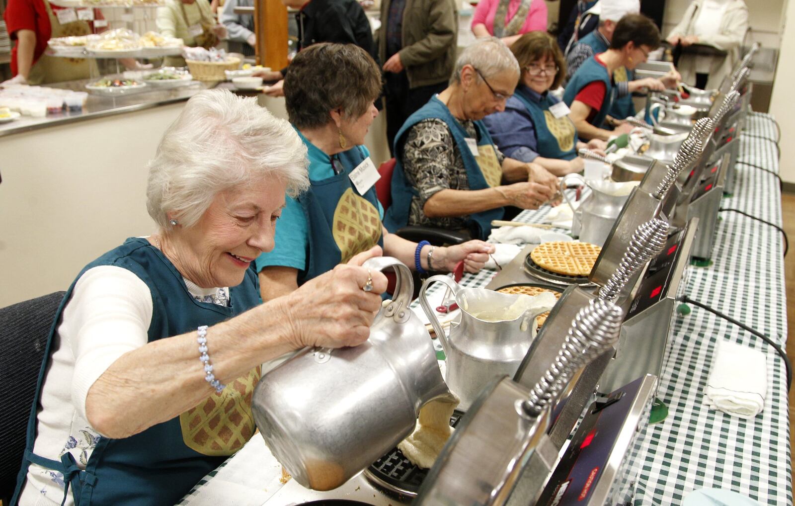It’s the season of giving. And what better way to give than to get waffles in return. Katie Russell of Beavercreek pours batter into a waffle iron during a past Waffle Shop held at Christ Episcopal Church in Dayton. A craft bazaar and bake sale are also part of the event. LISA POWELL / STAFF