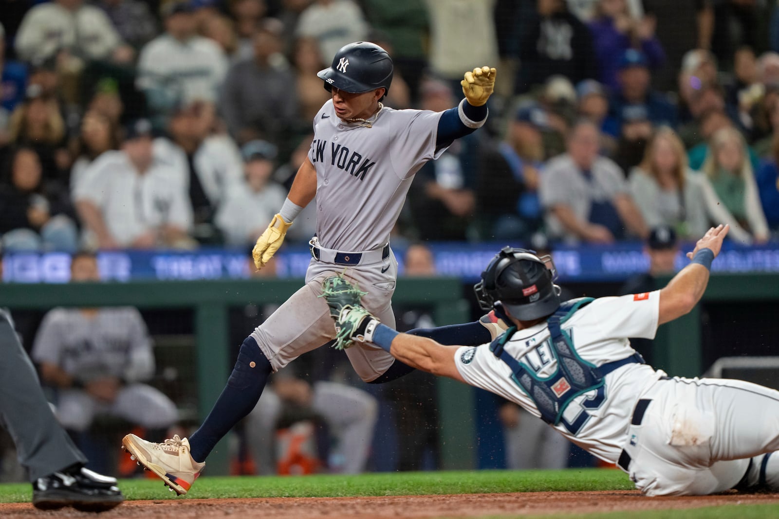 New York Yankees' Oswaldo Cabrera scores a run ahead of a tag by Seattle Mariners catcher Cal Raleigh during the ninth inning of a baseball game, Monday, May 12, 2025, in Seattle. (AP Photo/Stephen Brashear)