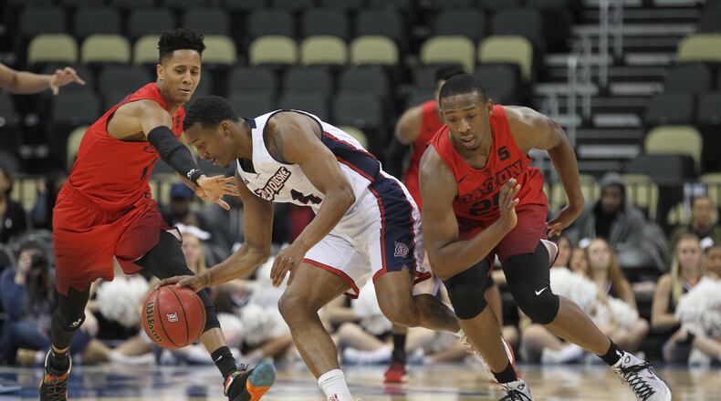 Dayton’s Darrell Davis, left, and Kendall Pollard, right, guard Duquesne’s Rene Castro on Saturday, Jan. 14, 2017, at PPG Paints Arena in Pittsburgh. David Jablonski/Staff