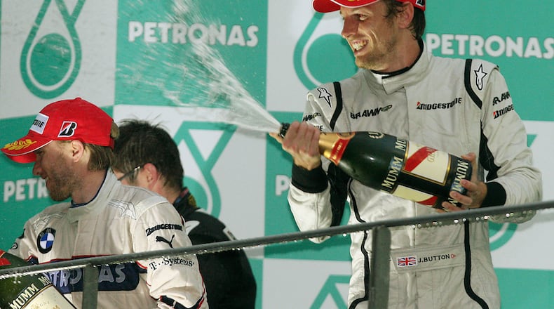 FILE - Brawn GP Formula One driver Jenson Button of Britain, right, BMW Sauber Formula One driver Nick Heidfeld of Germany celebrate during the award ceremony of the Malaysia Formula One Grand Prix at the Sepang racetrack in Kuala Lumpur, Sunday, April 5, 2009. (AP Photo/Eugene Hoshiko, File)