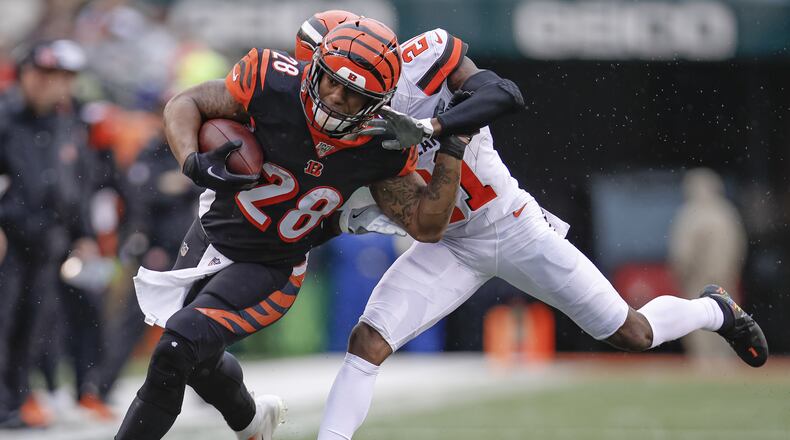 CINCINNATI, OH - DECEMBER 29: Joe Mixon #28 of the Cincinnati Bengals runs the ball as he is hit by Denzel Ward #21 of the Cleveland Browns during the first half at Paul Brown Stadium on December 29, 2019 in Cincinnati, Ohio. (Photo by Michael Hickey/Getty Images)