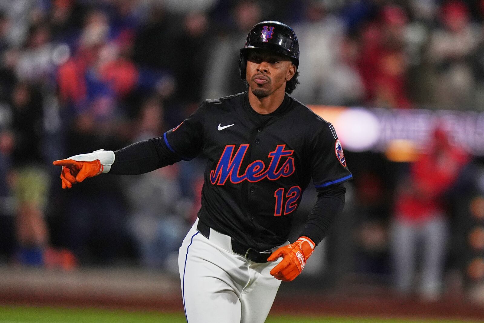 New York Mets' Francisco Lindor (12) gestures to teammates as he runs the bases after hitting a walk-off home run during the ninth inning of a baseball game against the St. Louis Cardinals Friday, April 18, 2025, in New York. (AP Photo/Frank Franklin II)